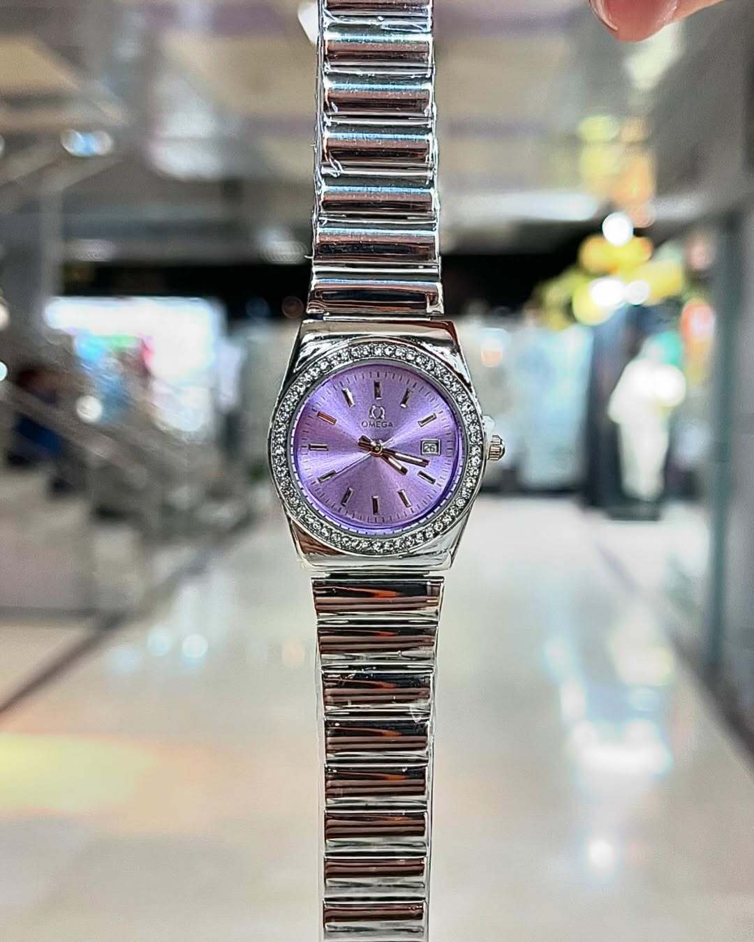 نمای نزدیک ساعت مچی زنانه اومگا OMEGA بند استیل نگین دار رنگ بنفش